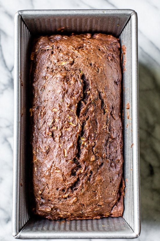 This Chocolate Zucchini Bread is so rich and delicious, no one will guess that it's secretly healthy! Add walnuts for crunch in every bite. Overhead view of chocolate zucchini bread in pan