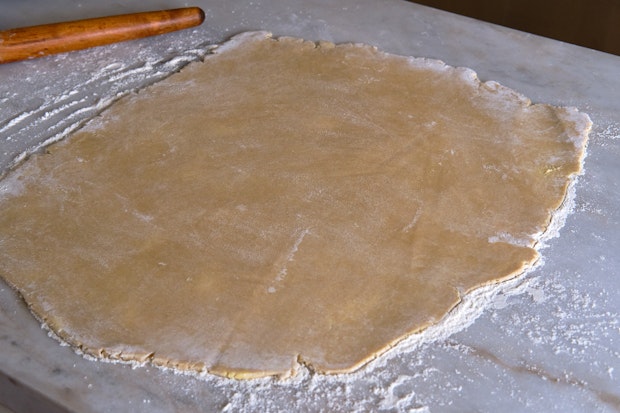 pie dough rolled out on marble counter