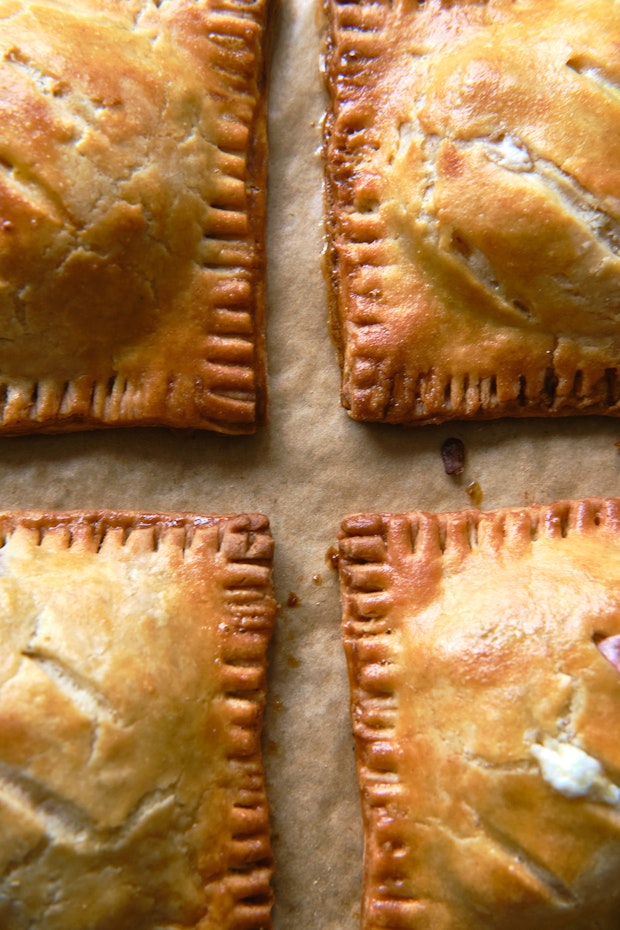 close up photo of peach hand pies on a baking sheet