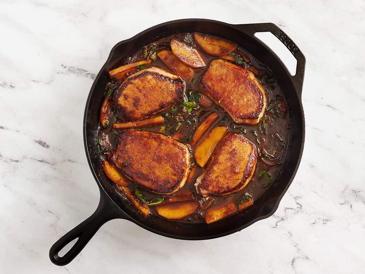 Finished apple butter pork chops in a skillet.