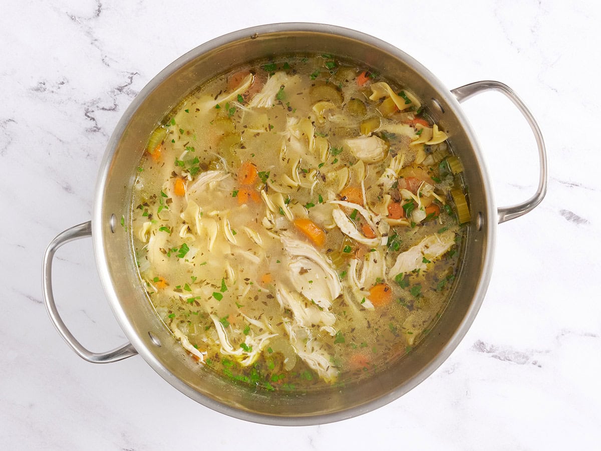 Finished chicken noodle soup in a soup pot.