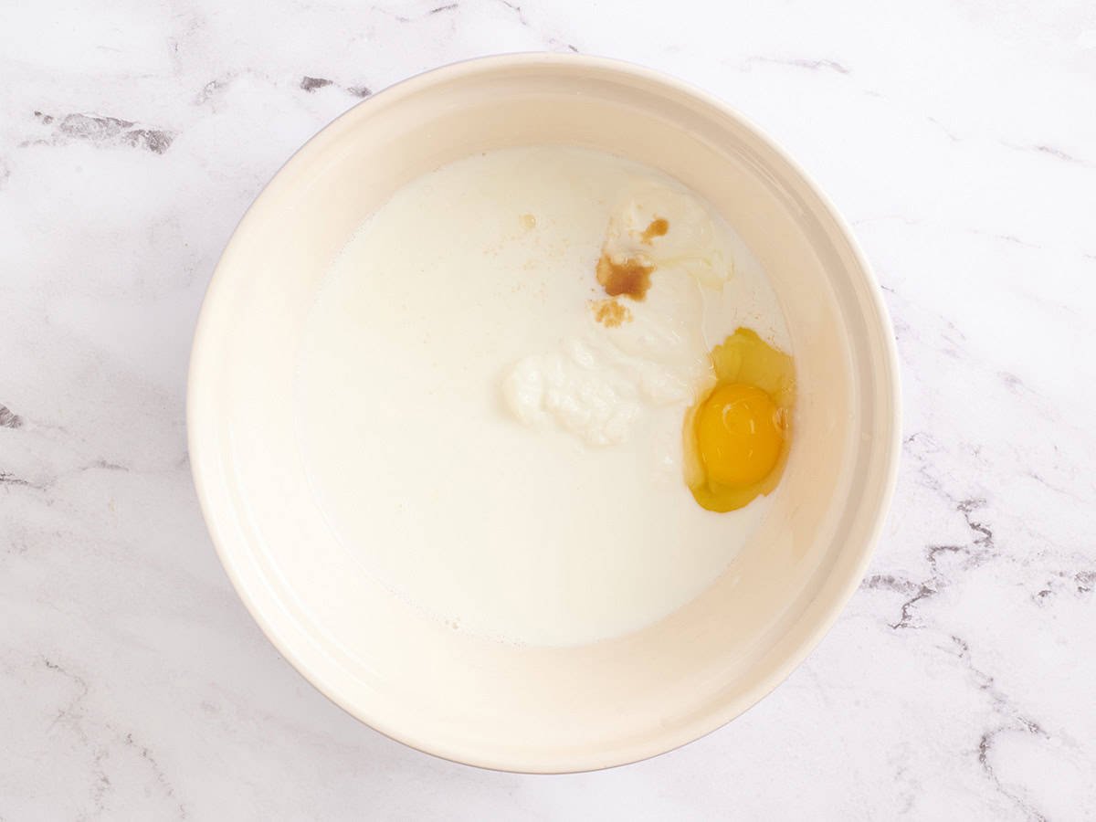 Milk, yogurt, and egg in a mixing bowl.