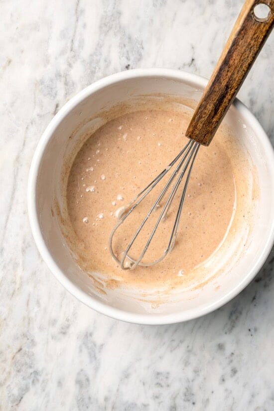 Overhead view of spiced glaze in bowl with whisk