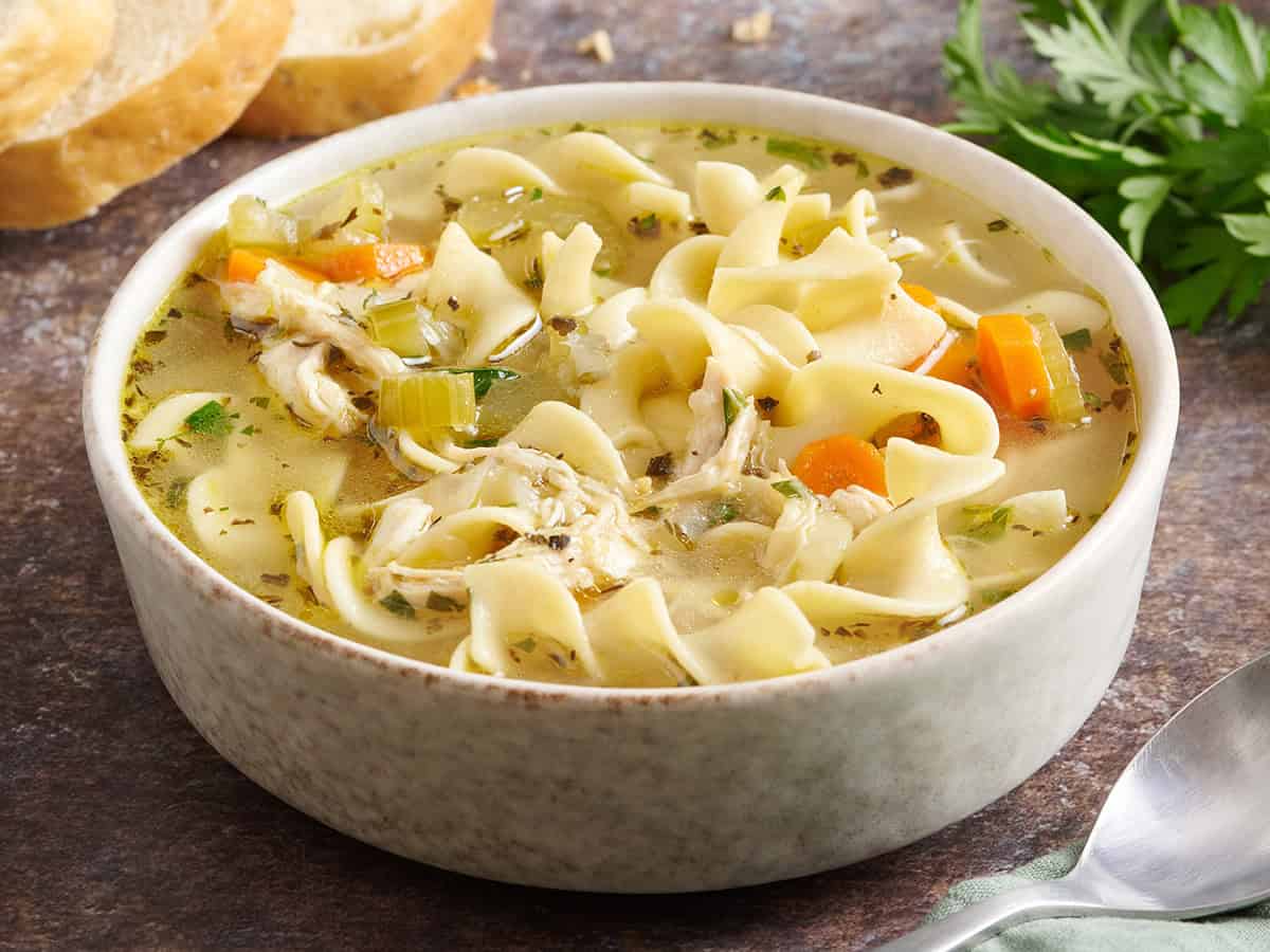 Side view of a bowl of chicken noodle soup.