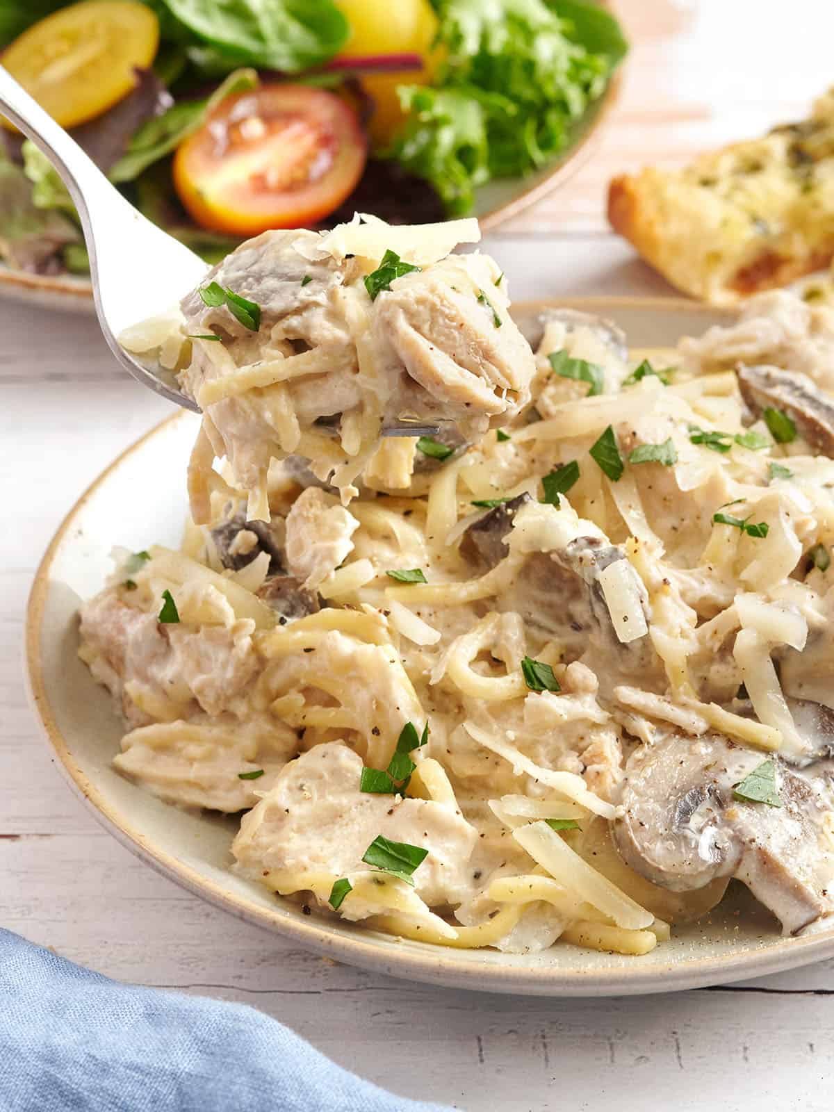 Plate full of crockpot Chicken Tetrazzini with a fork scooping some out