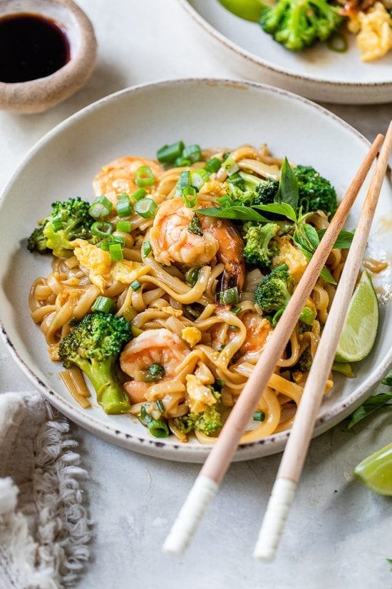 Drunken Noodles with Shrimp and chopsticks on a plate.