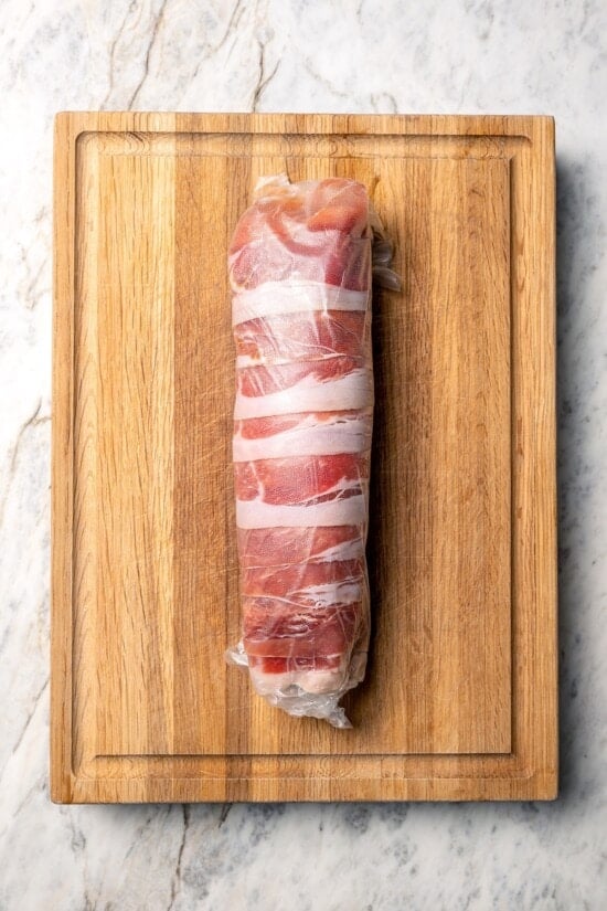 This Prosciutto Wrapped Stuffed Turkey Tenderloin recipe is filled with apples, cheese and kale for a healthy high-protein dinner. Delicious! Turkey tenderloin wrapped in prosciutto and layer of plastic wrap.