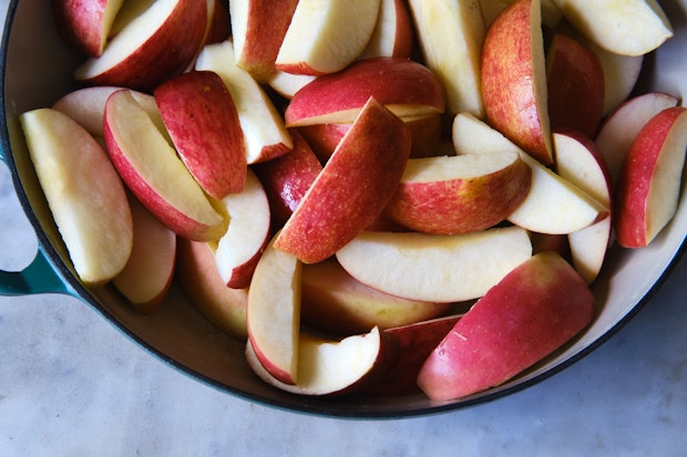 Quartered apples piled into a large pot