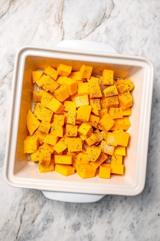 Seasoned butternut squash in baking dish.