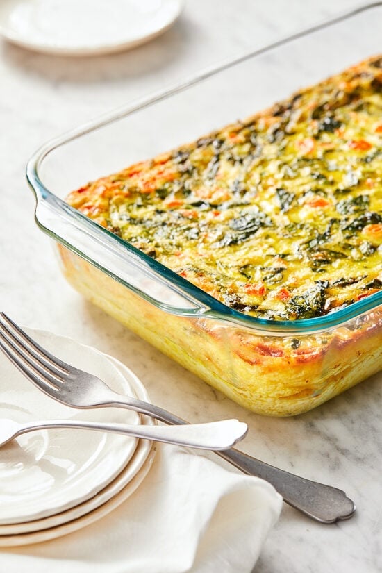 This easy Breakfast Casserole recipe is made with eggs, spinach, tomatoes and Feta cheese and only takes a few minutes to whip up. You can make it ahead of time, so it’s the perfect breakfast egg casserole for Christmas morning or any day!