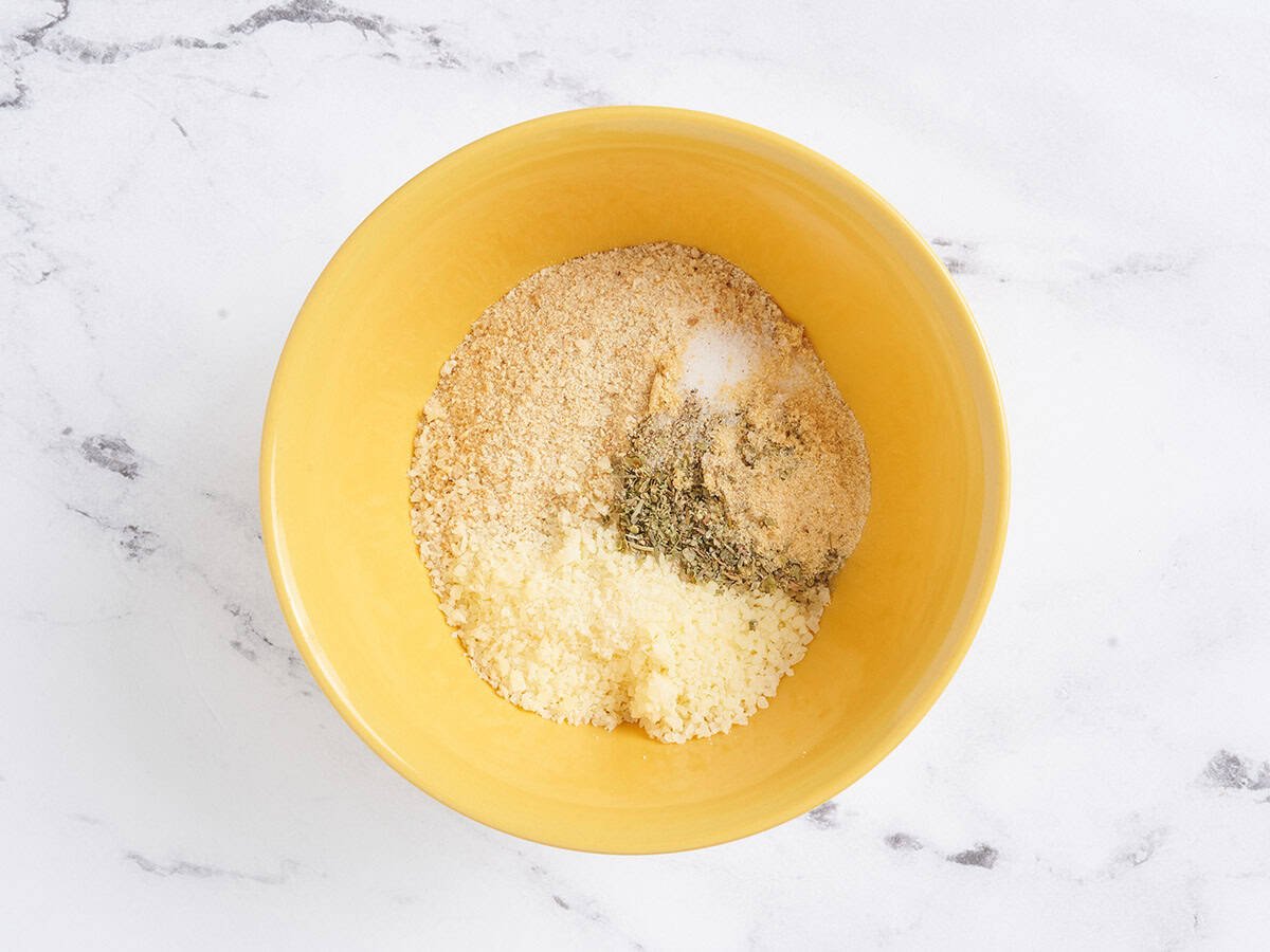 Breadcrumbs, grated parmesan and seasonings in a bowl.