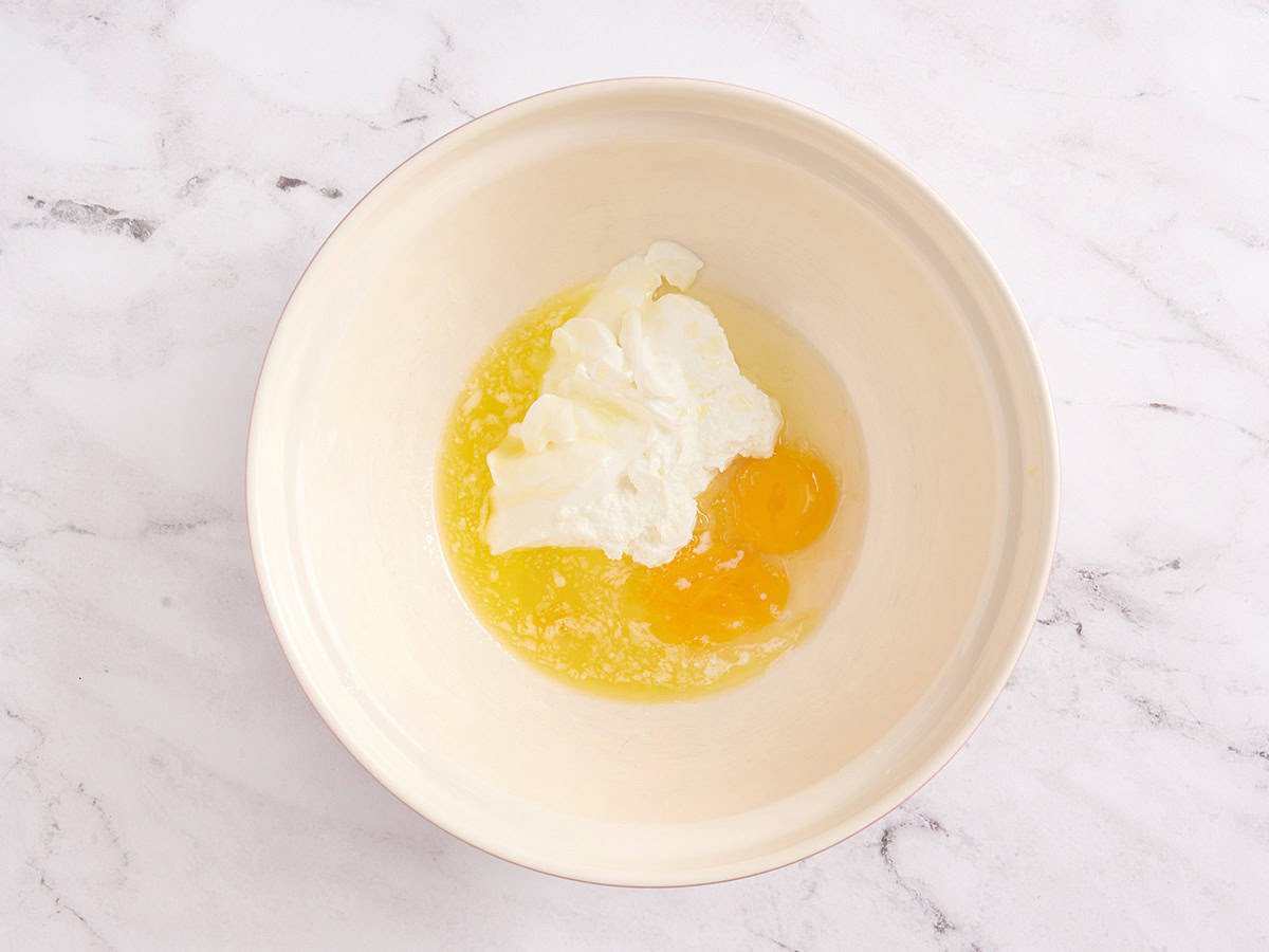 Combining the wet ingredients in a white bowl.