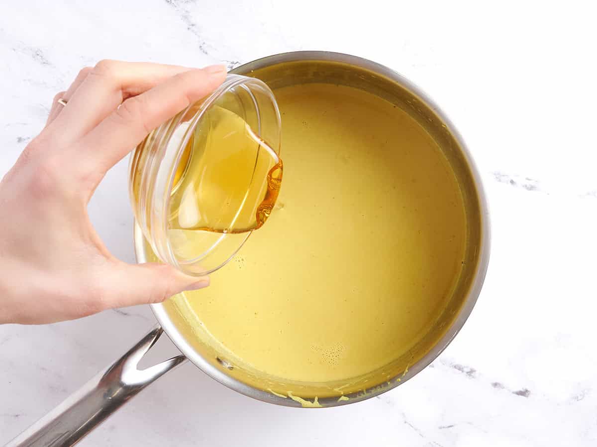 Adding honey to the pot of golden milk.