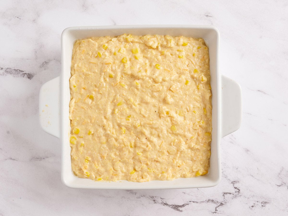 Cornbread batter in a white baking dish.