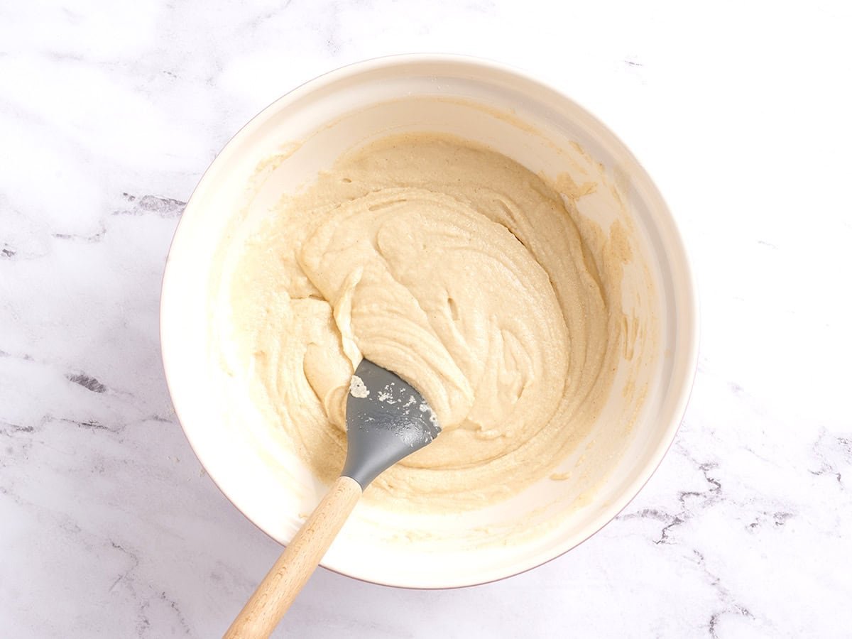 Tamale dough in a bowl with a spatula.