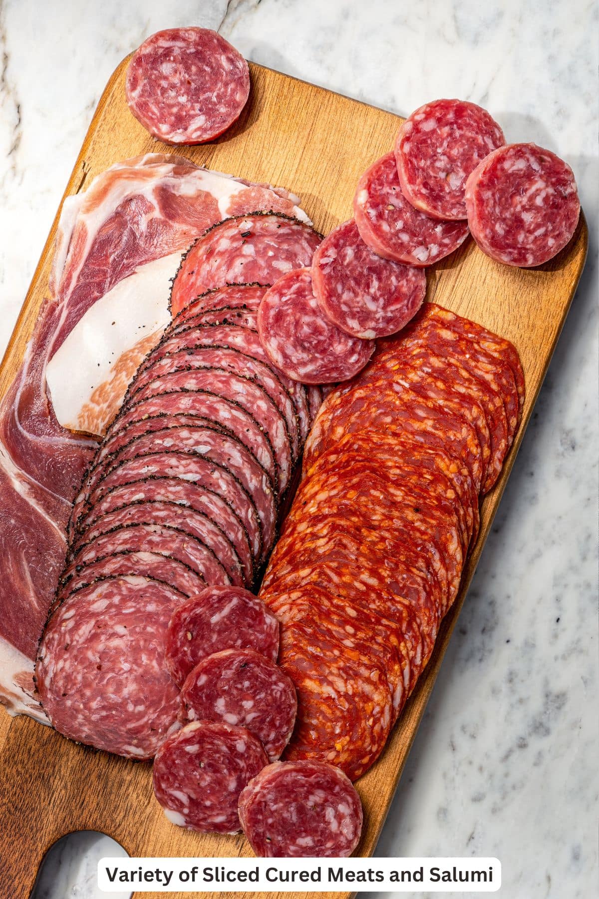 Your ultimate guide to creating a charcuterie and cheese board! I'll show you how to choose and arrange everything for a beautiful spread. Cured meats and salami on wooden board.