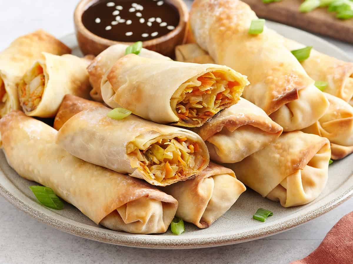 Side view of homemade vegetable egg rolls on a plate.