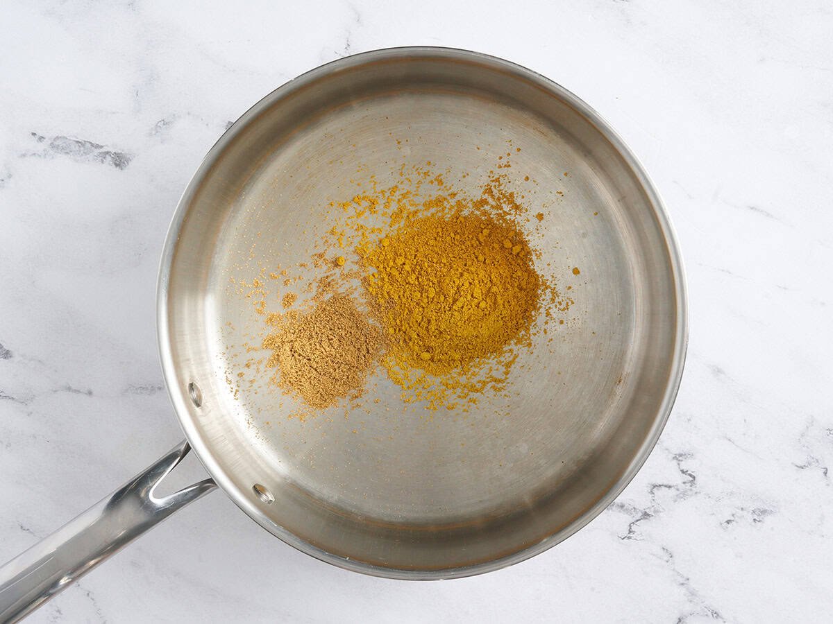 Spices toasting in a skillet.