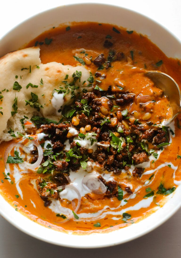 Carrot soup with spiced ground beef on top.