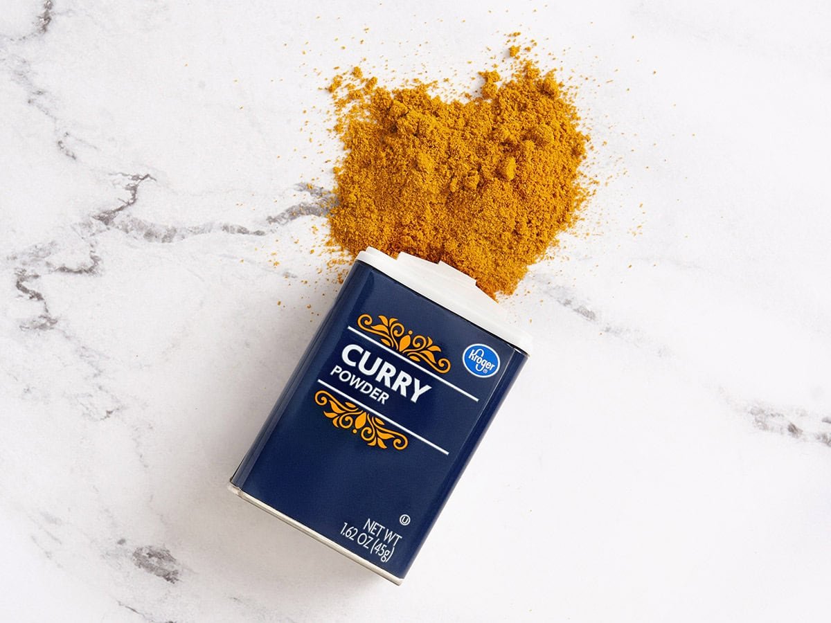 A spilt pot of Kroger brand curry powder.